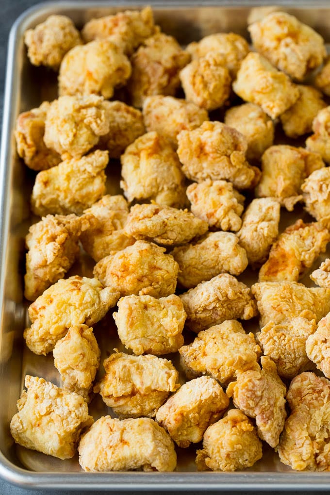 Deep fried chicken pieces on a sheet pan.