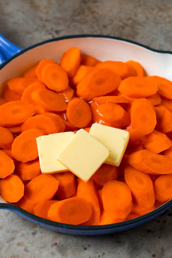 Cooked carrots, butter and honey in a pan.