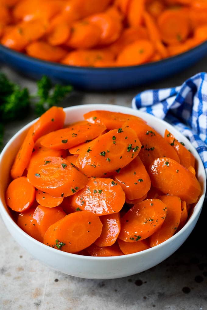 A serving bowl of honey glazed carrots.