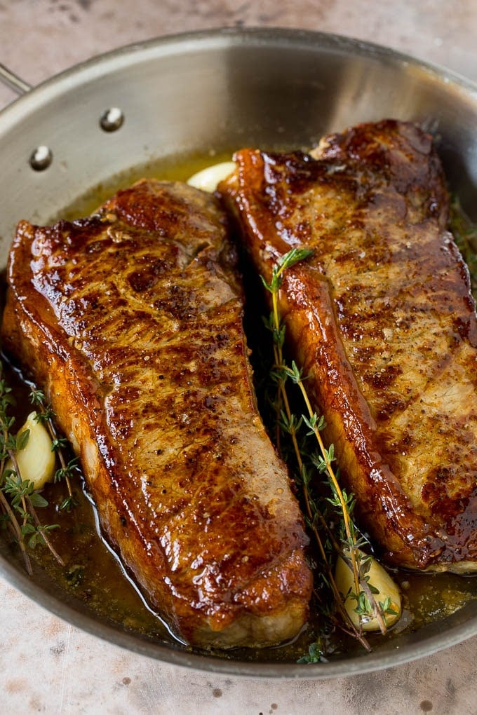 Strip steaks with butter, garlic and herbs.