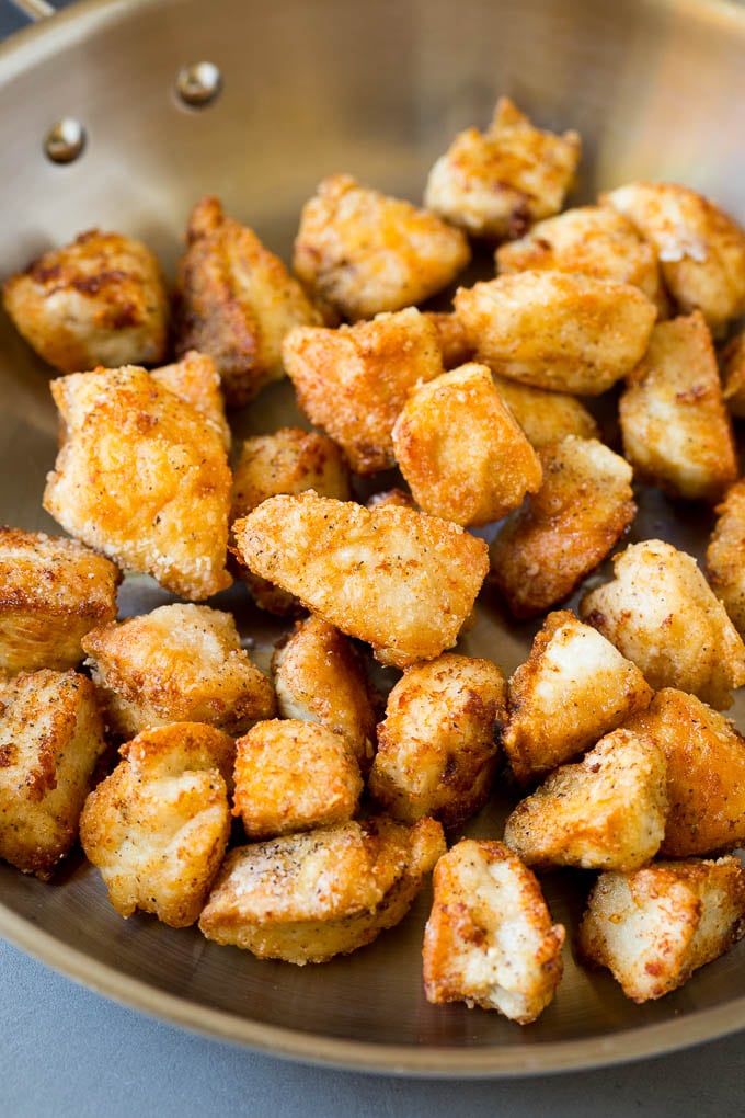 Golden brown chicken breast pieces in a skillet.