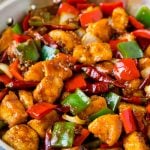 Szechuan chicken with vegetables and chili peppers in a skillet.