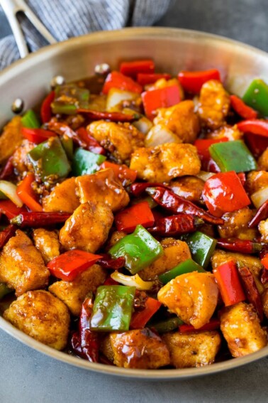 Szechuan chicken with vegetables and chili peppers in a skillet.