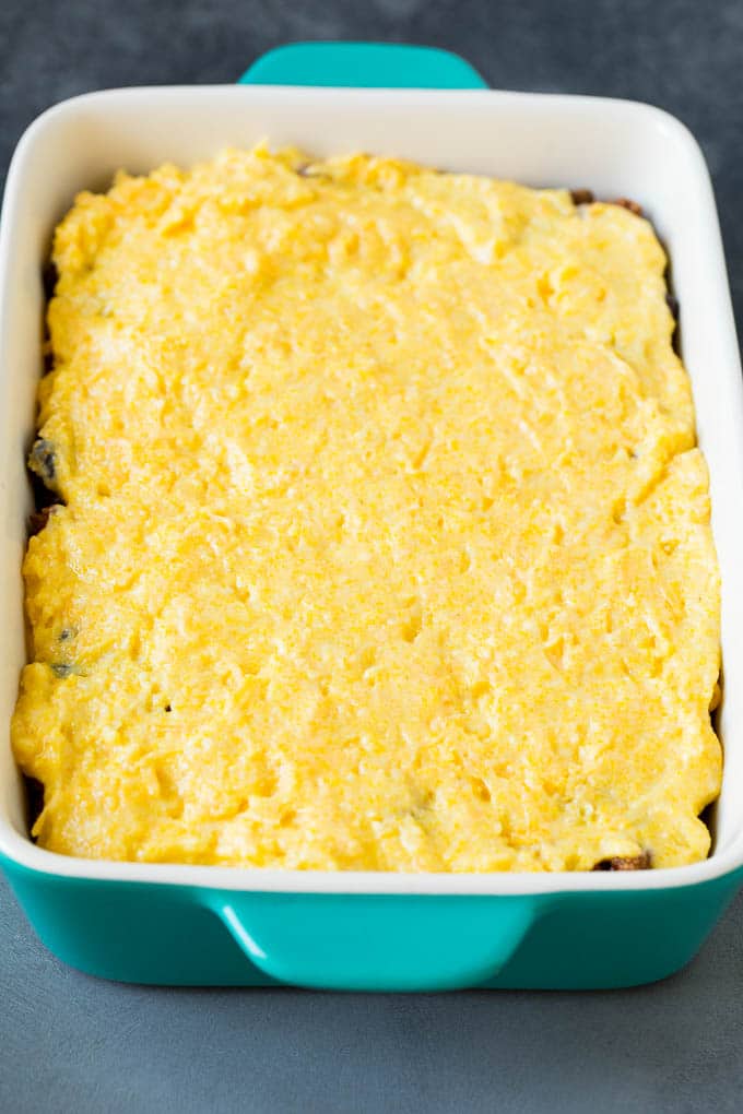 Beef in a casserole dish with a cornbread batter on top.