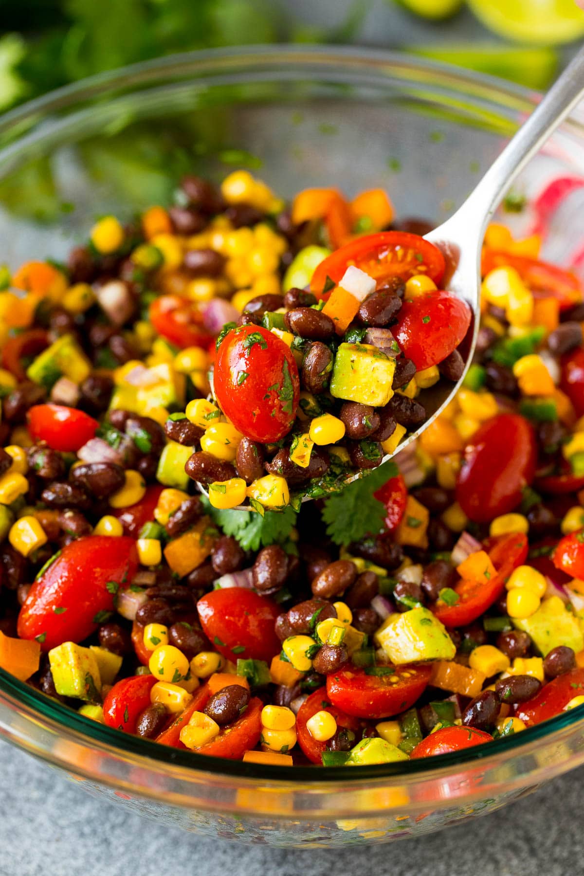 A serving spoon full of black bean salad.