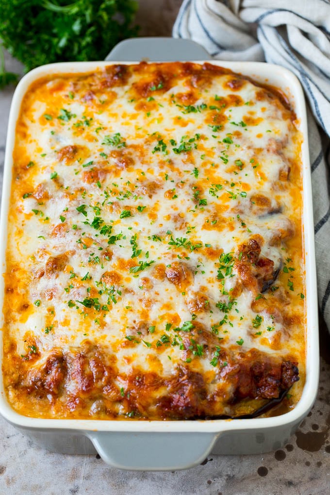 Baked eggplant lasagna with a garnish of chopped parsley.