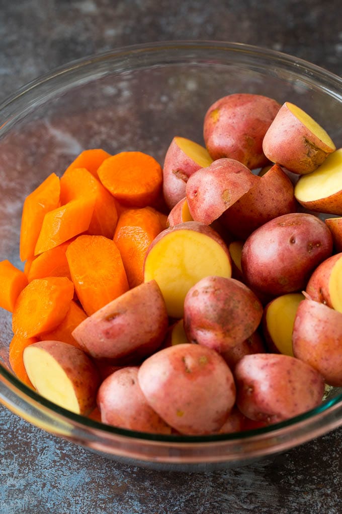 Halved potatoes and sliced carrots in a bowl.