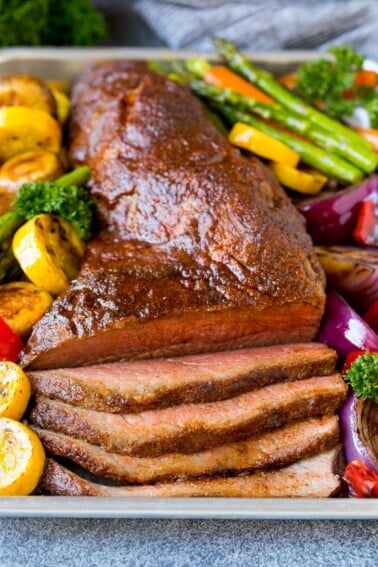 A platter of smoked tri tip served with vegetables.