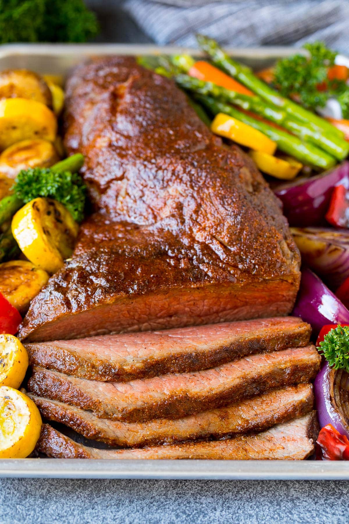 A platter of smoked tri tip served with vegetables.