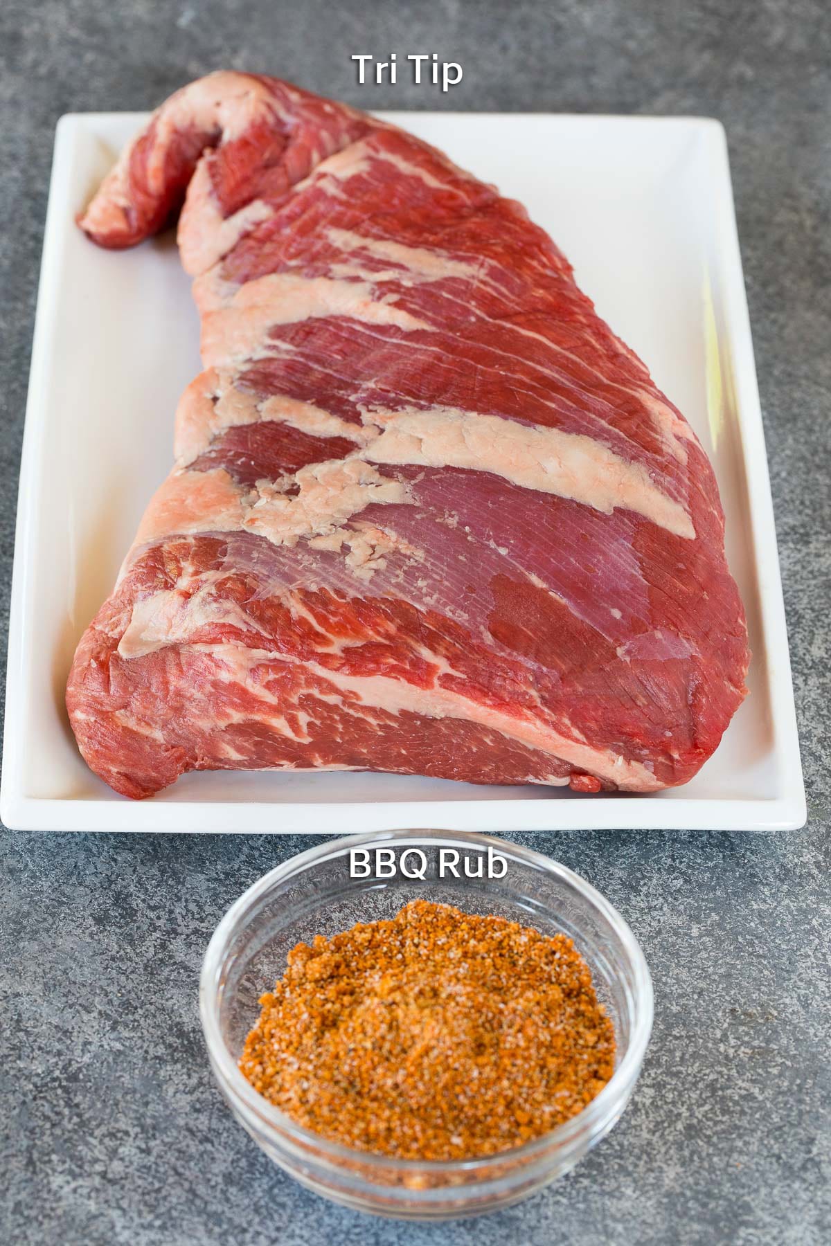 A beef roast and a bowl of BBQ rub.