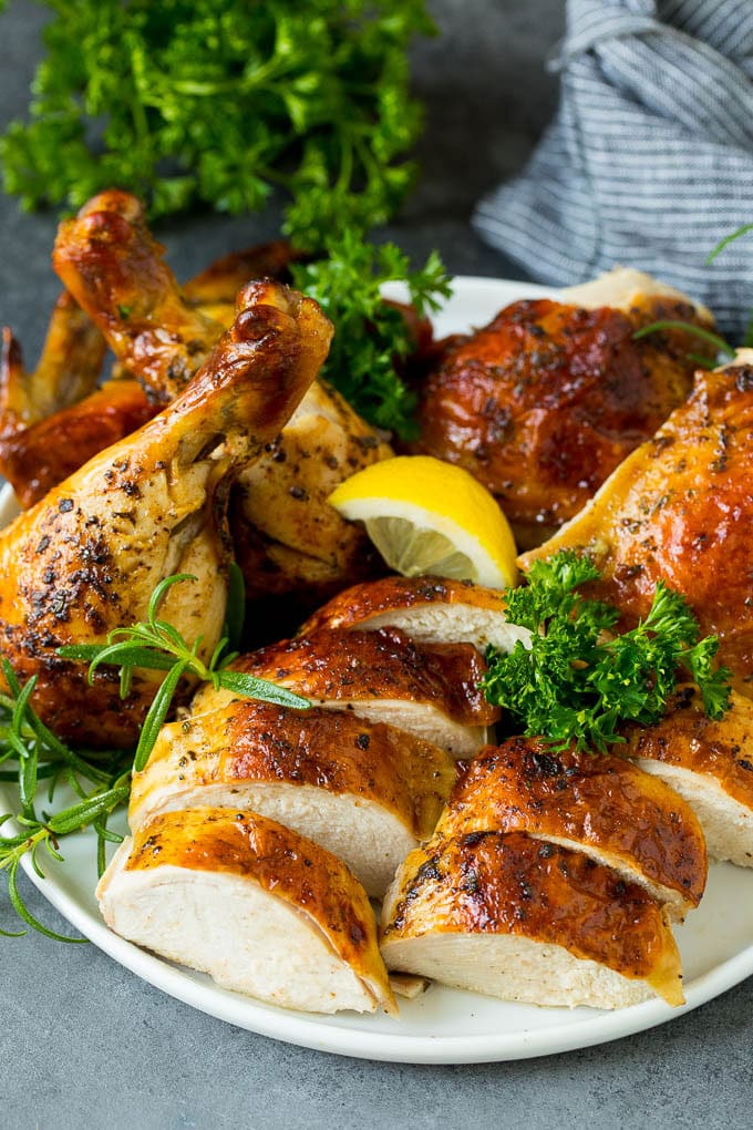 A carved spatchcock chicken on a serving plate.