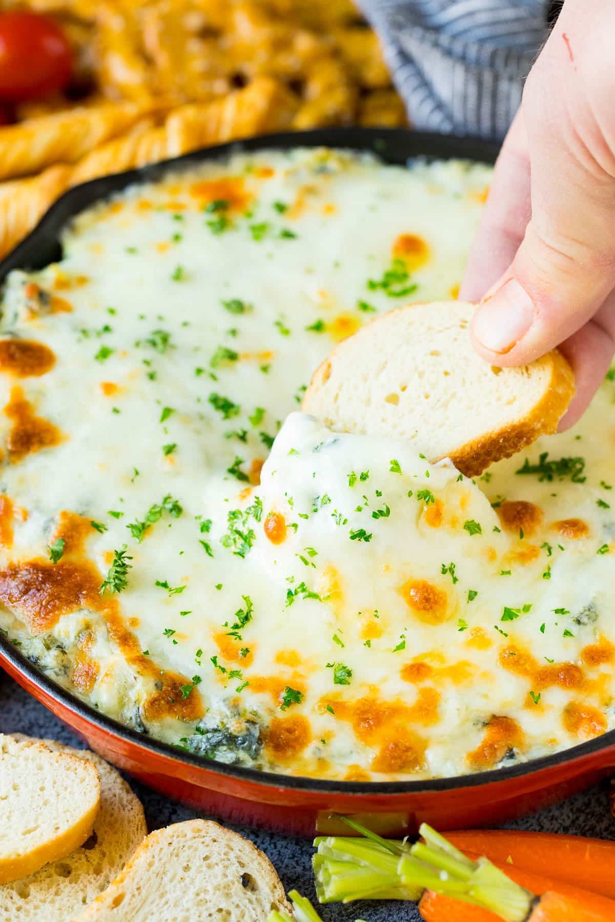 Bread in a pan of cheesy dip.