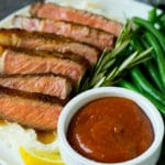 Homemade steak sauce served with sliced steak and green beans.