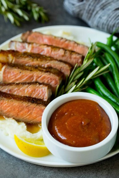 Homemade steak sauce served with sliced steak and green beans.