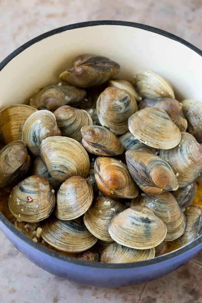 Littleneck clams in a pot with butter and white wine.