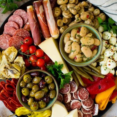 An antipasto platters with meats, cheeses, olives and vegetables.