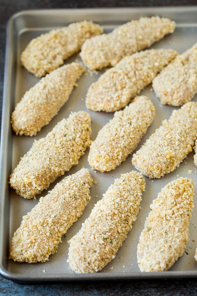 Breaded chicken fingers on a sheet pan.