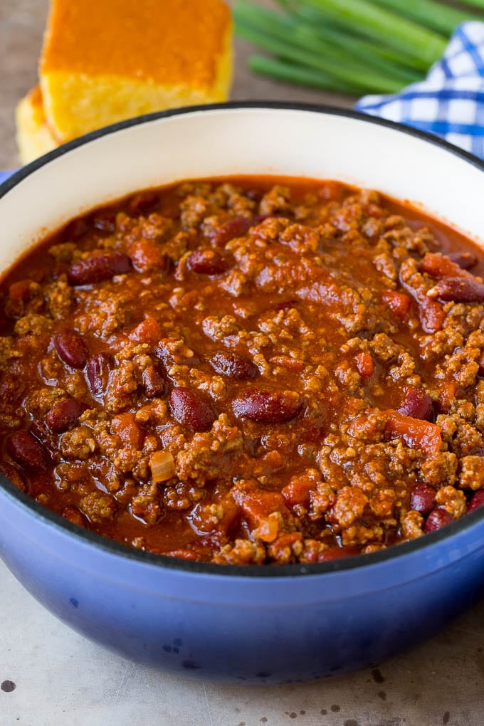 A pot of beef chili with beans, served with cornbread.