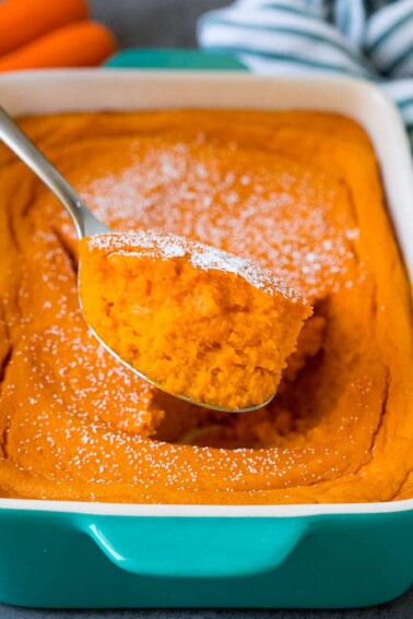 A spoon serving up a portion of carrot souffle.
