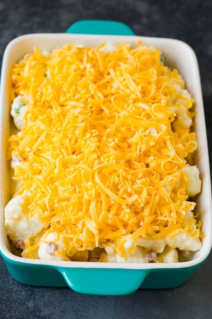 Florets in a baking dish, topped with shredded cheese.