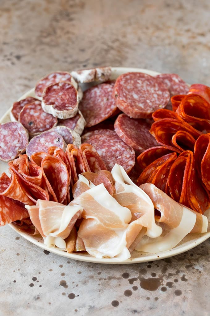 Prosciutto and a variety of salami on a plate.