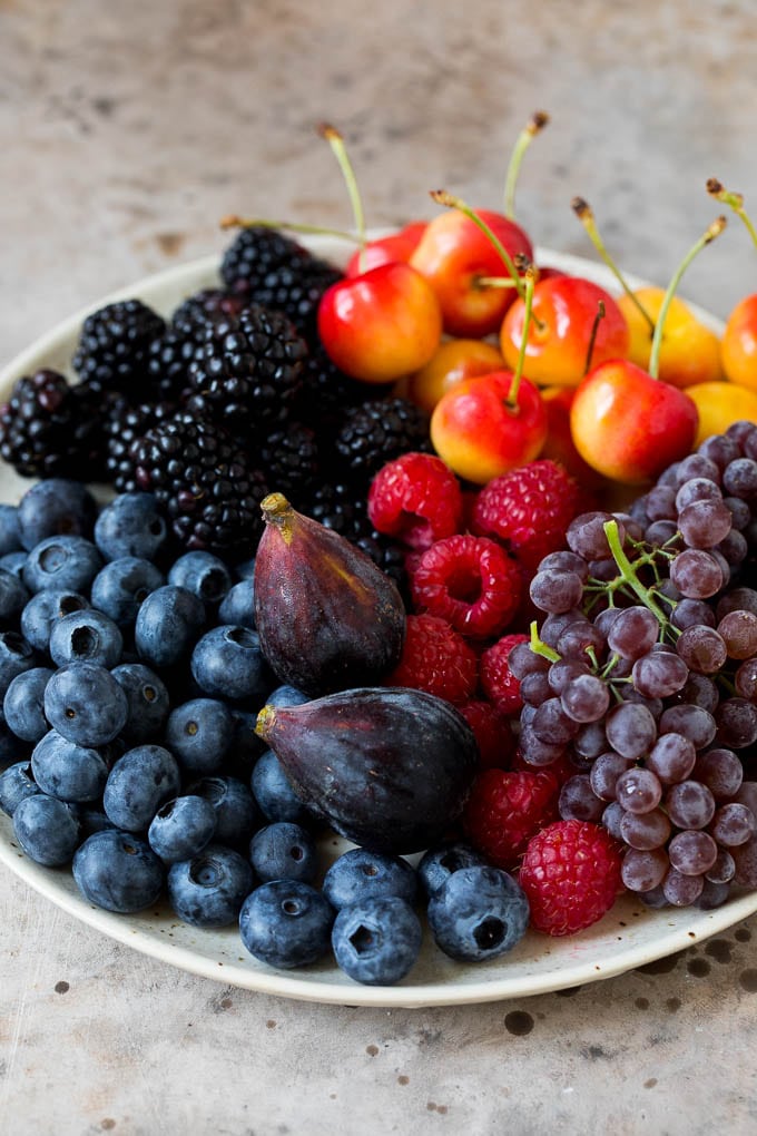 A plate of berries, cherries, grapes and figs.