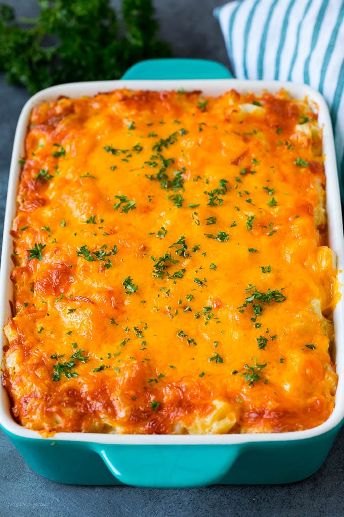 Cheesy potatoes in a casserole dish topped with melted cheddar and parsley.