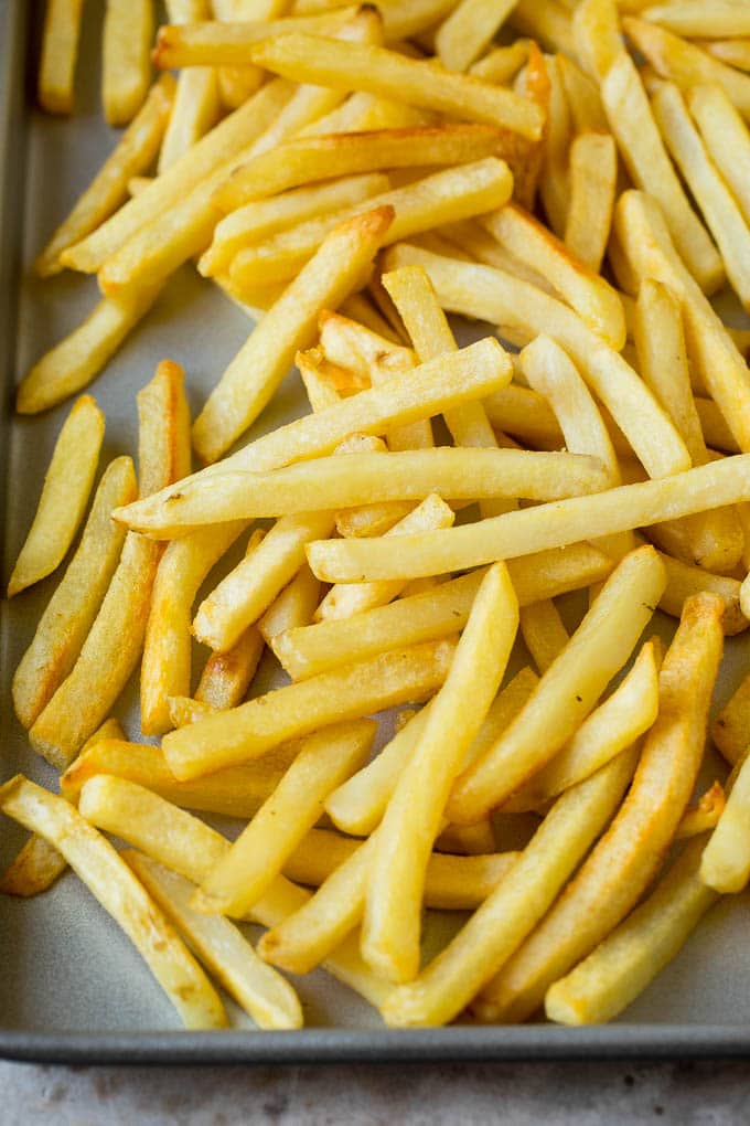 Baked french fries on a sheet pan.