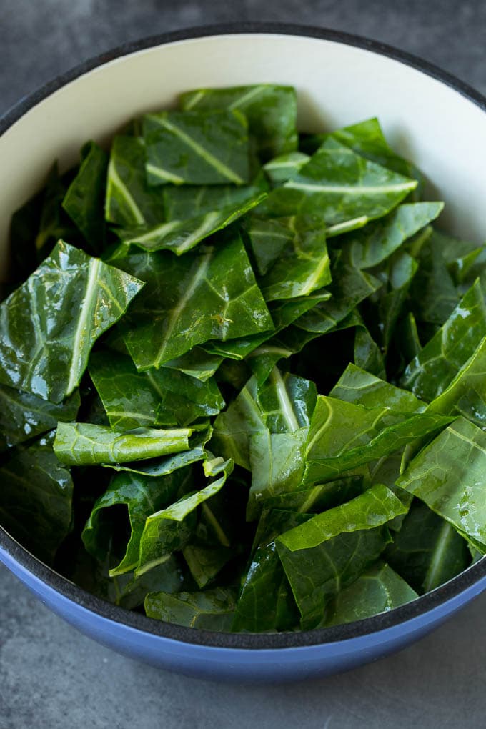 These Southern style collard greens are simmered with bacon and seasonings until tender and flavorful. Raw chopped collard leaves in a pot.