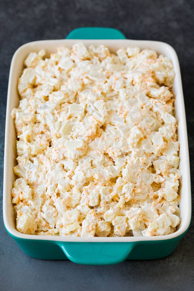 A mixture of potatoes with cheese and sour cream in a baking dish.