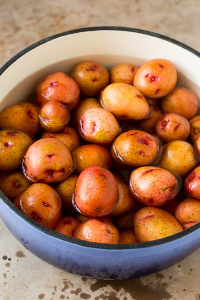 A pot of whole potatoes in boiling water.