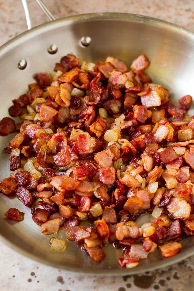 Bacon and onions cooked in a skillet.