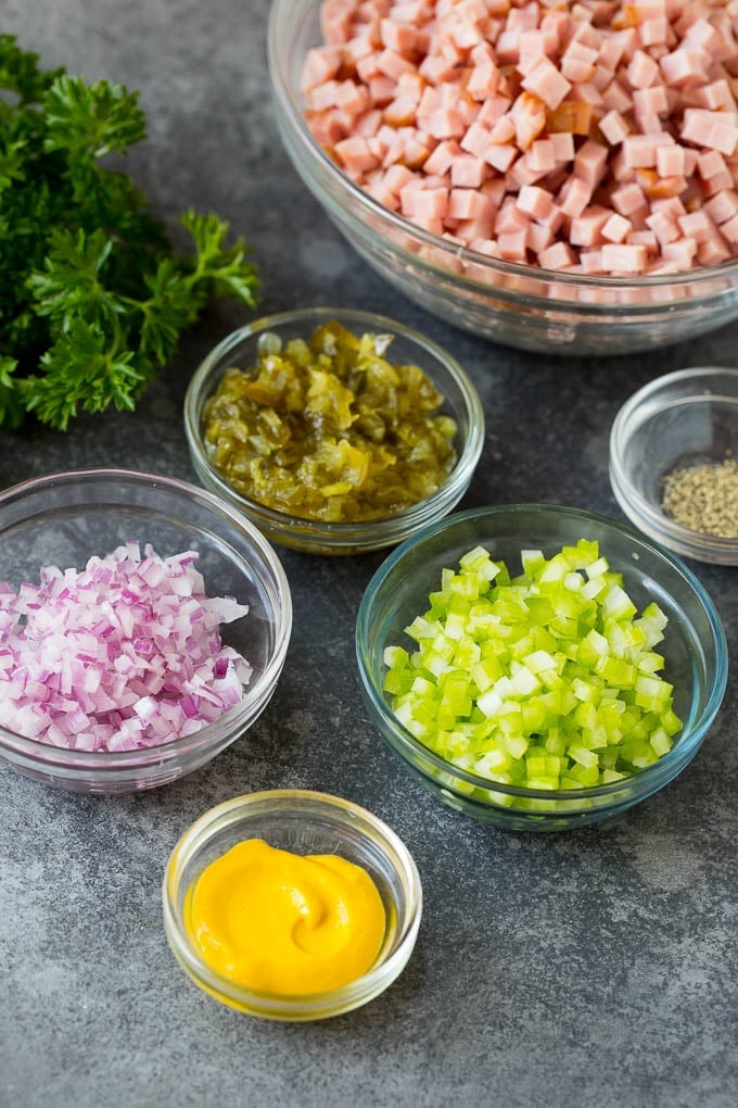 Bowls of diced meat, mustard, onion, celery and pickle relish.