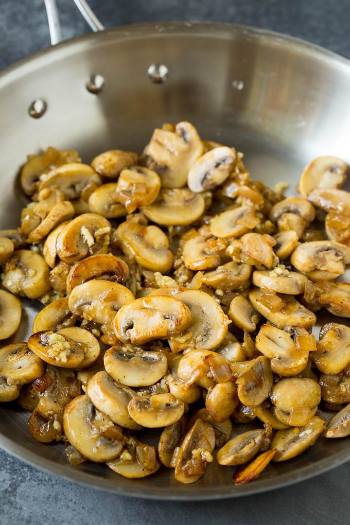 Sauteed mushrooms and onions in a pan.