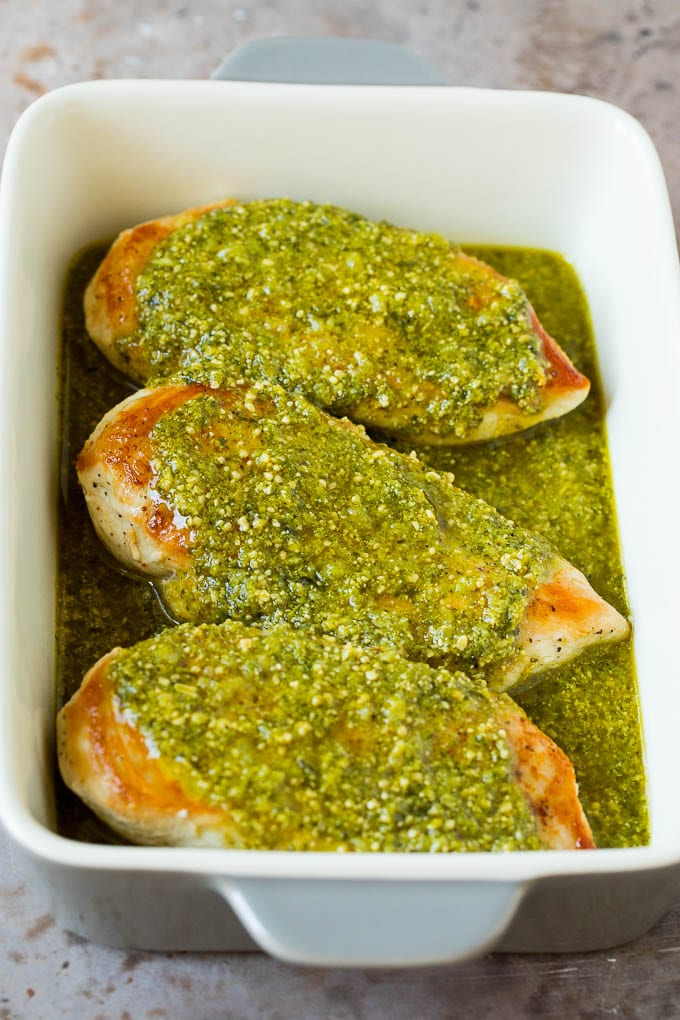 Chicken breasts covered in a pesto sauce.