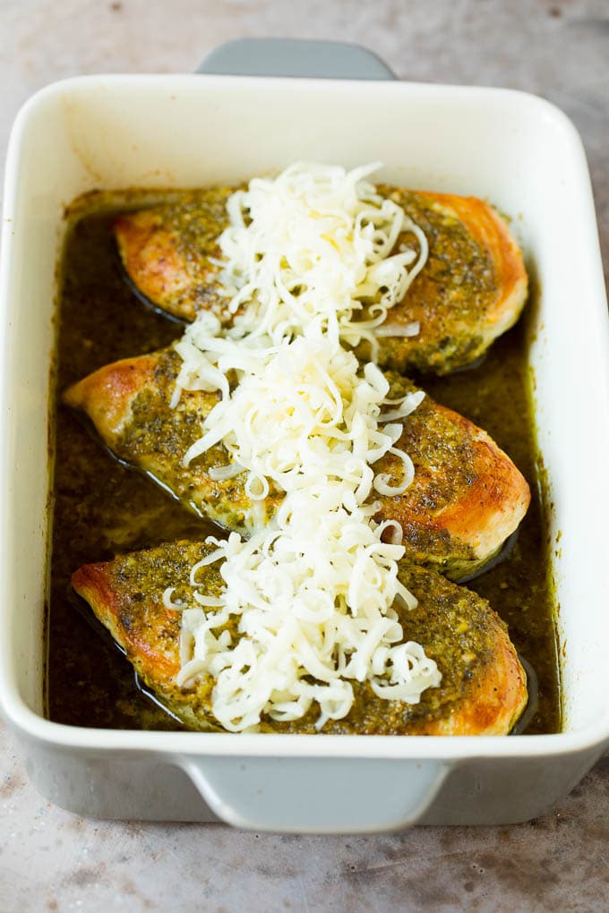 Baked chicken in basil sauce topped with shredded cheese.
