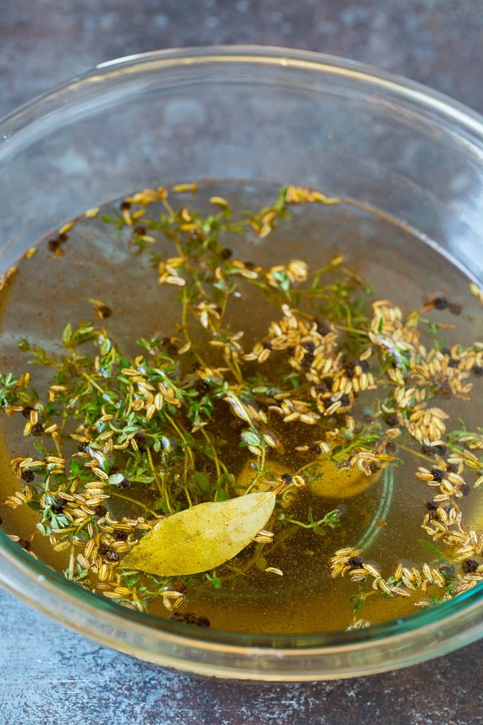 A bowl of pork chop brine made with fennel seeds, thyme, pepper and garlic.