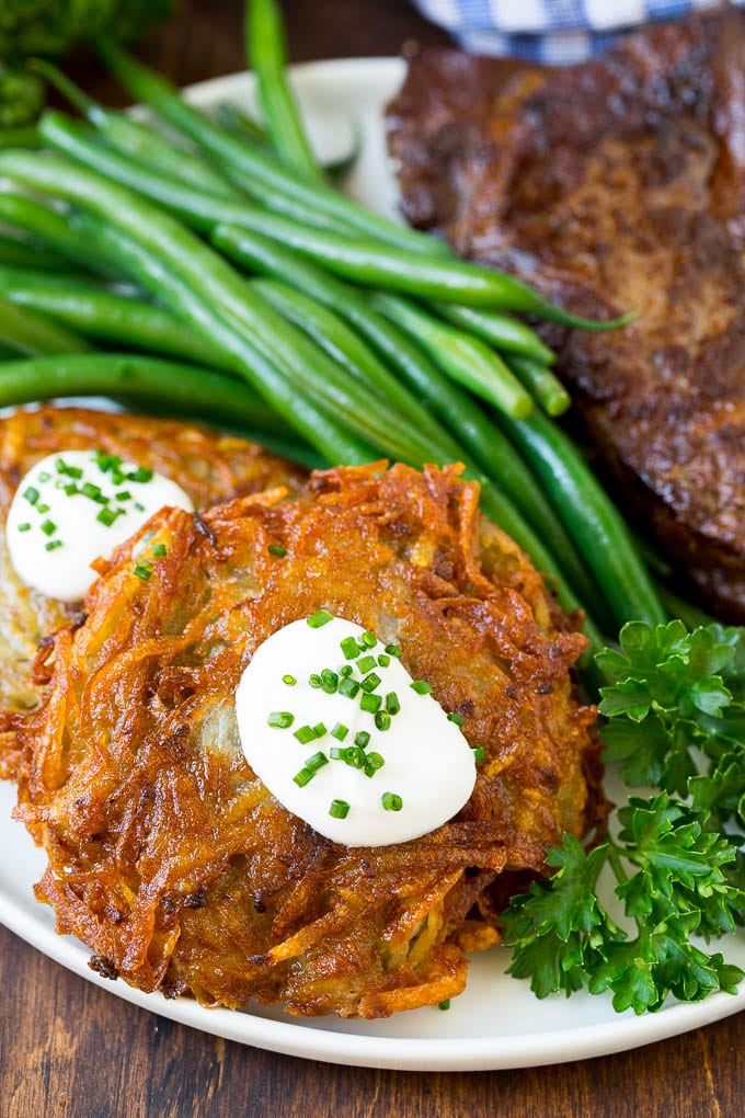 Potato pancakes served with steak and green beans.