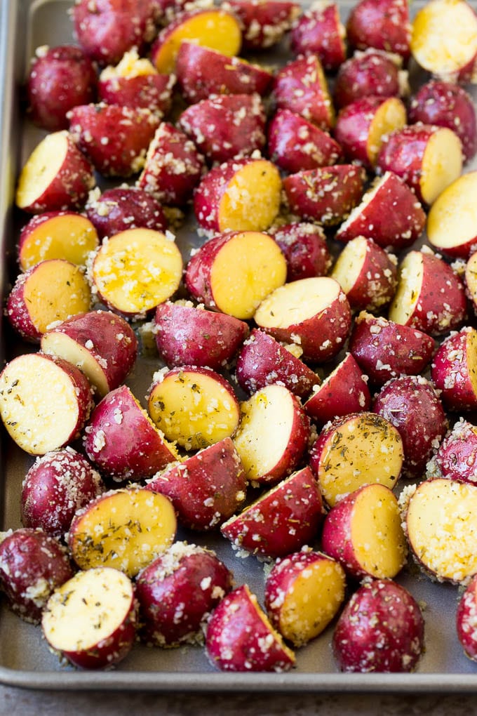 Seasoned potato halves on a sheet pan.