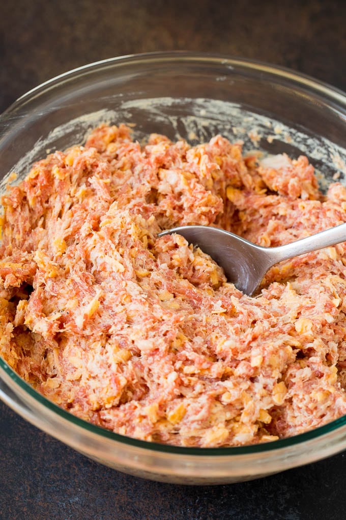 A mixture of sausage, cheese and seasonings in a glass bowl.