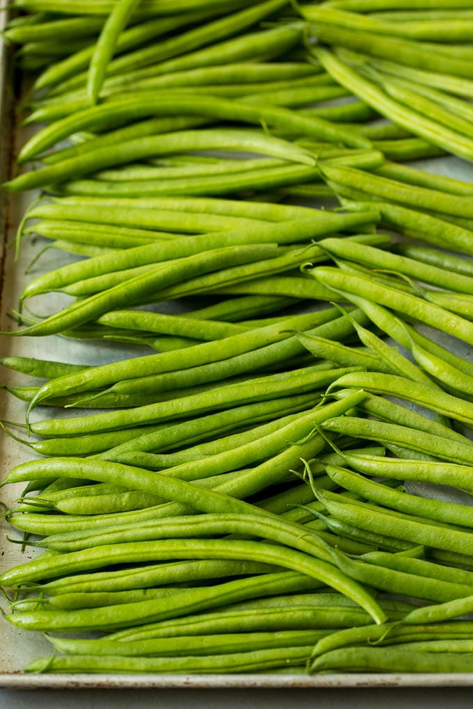 Raw green beans on a sheet pan.