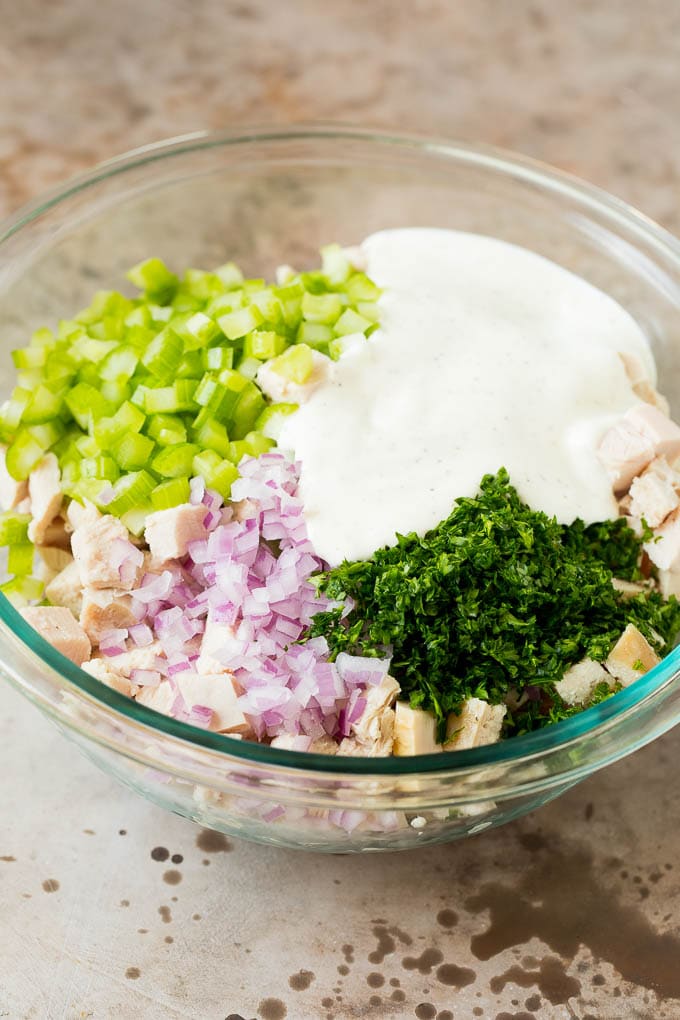 A bowl of turkey and vegetables with a creamy dressing poured over the top.