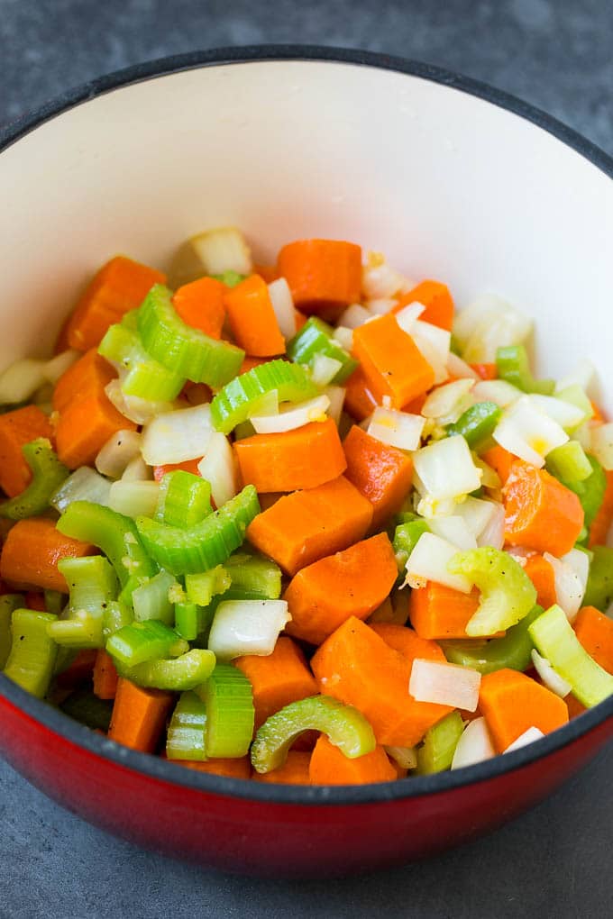Carrots, celery and onion cooked in a red pot.