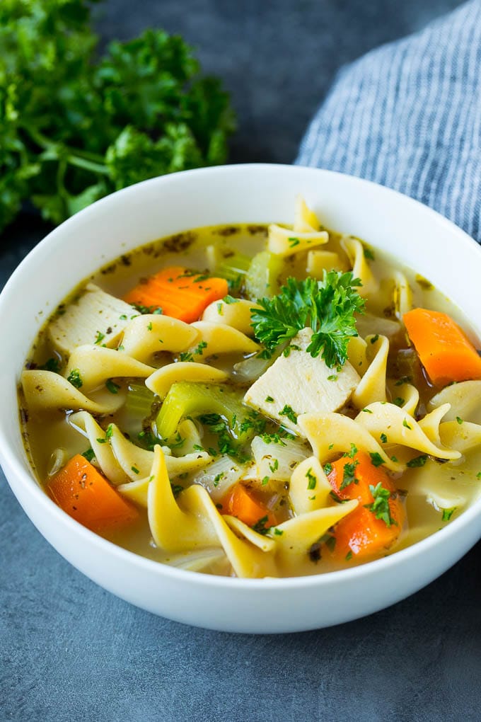 A bowl of turkey soup garnished with fresh parsley.