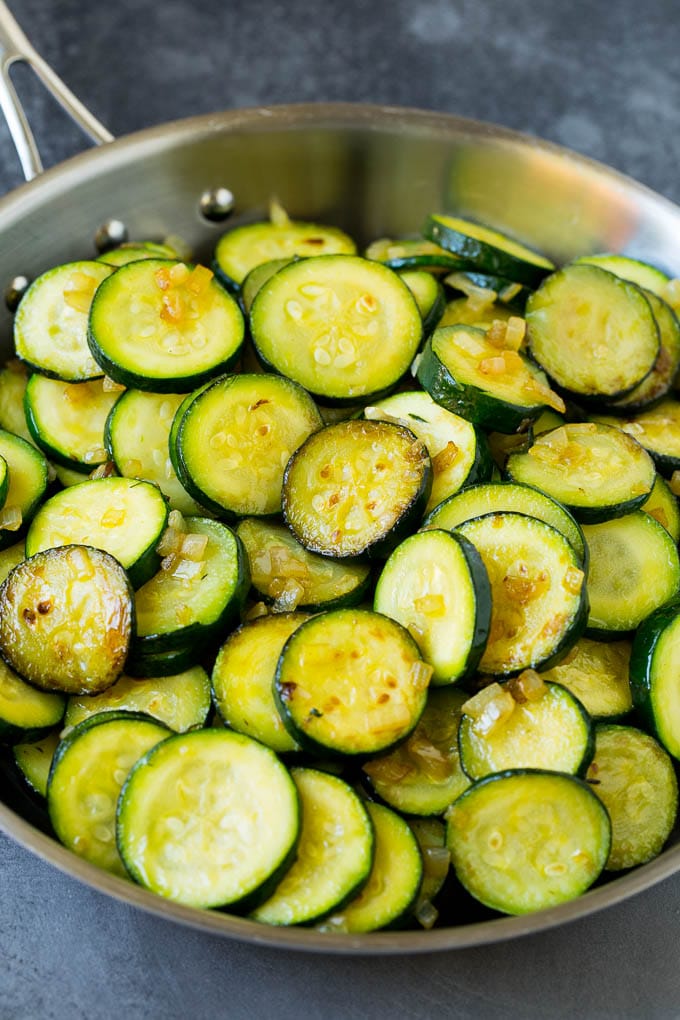 This zucchini casserole is sauteed squash tossed in a creamy sauce with plenty of cheese, all topped off with cracker crumbs and baked to perfection. Cooked slices of squash in a skillet.