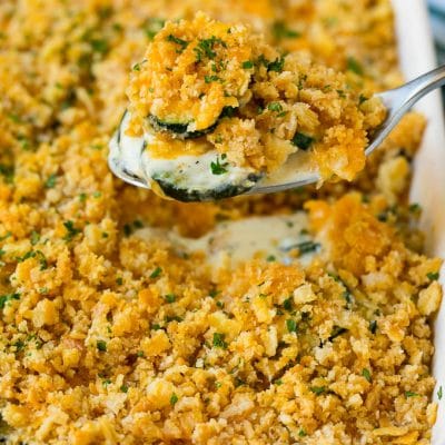 A spoon serving up a portion of zucchini casserole.