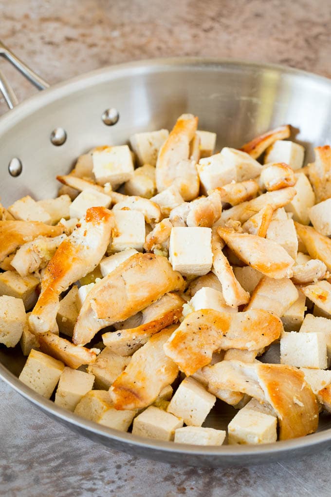 Chicken and tofu sauteed in a pan.