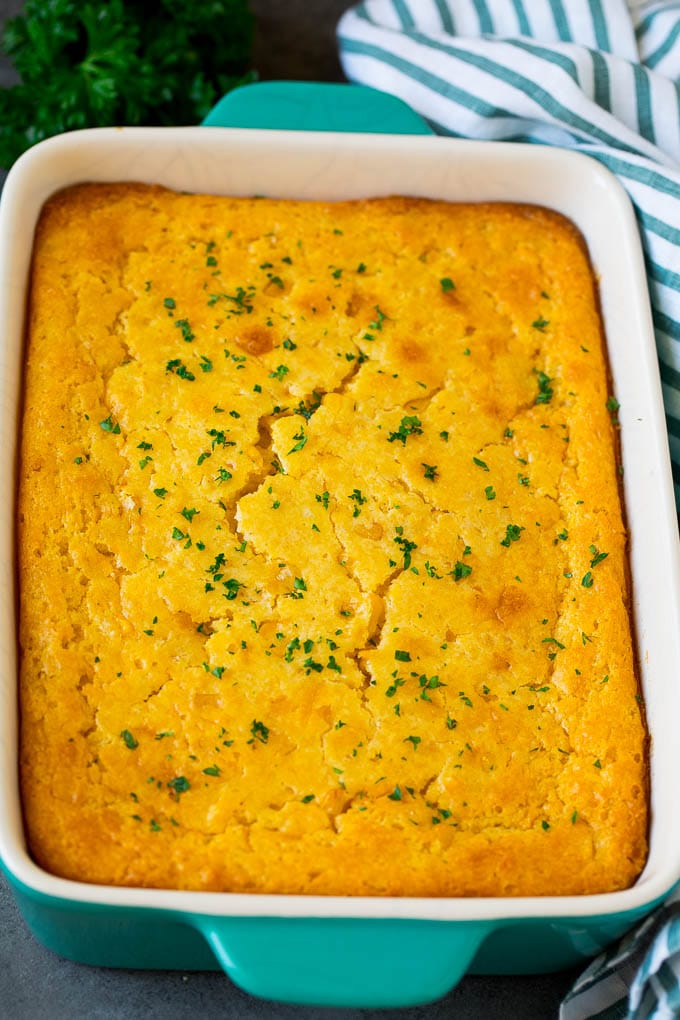 Corn souffle in a baking dish, topped with parsley.