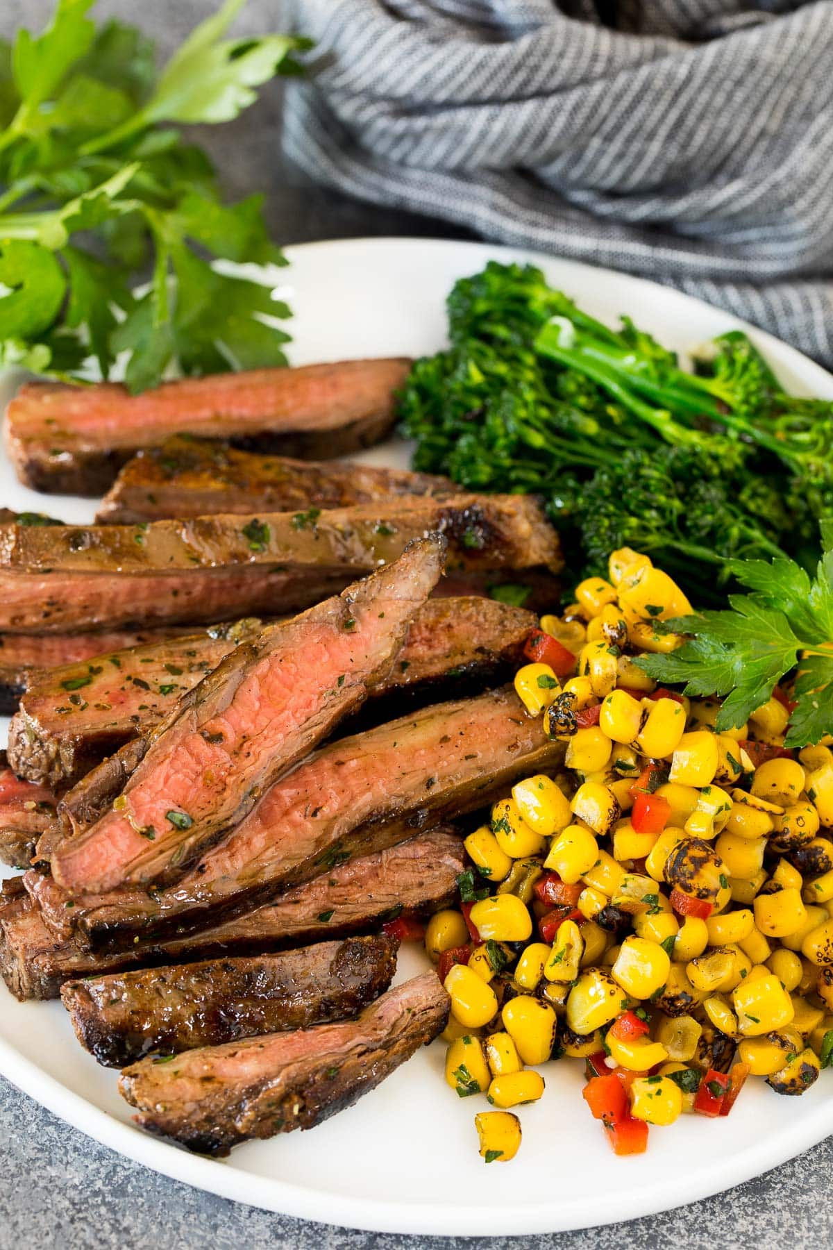 Grilled flank steak served with corn and broccoli.
