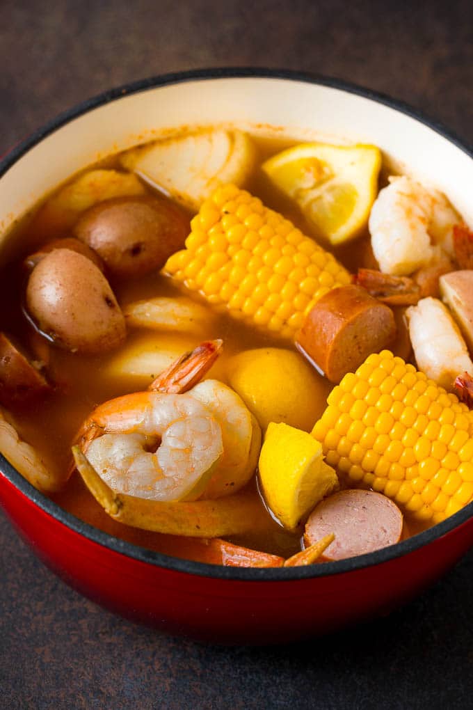 Boiled shrimp, potatoes and corn in a red pot.